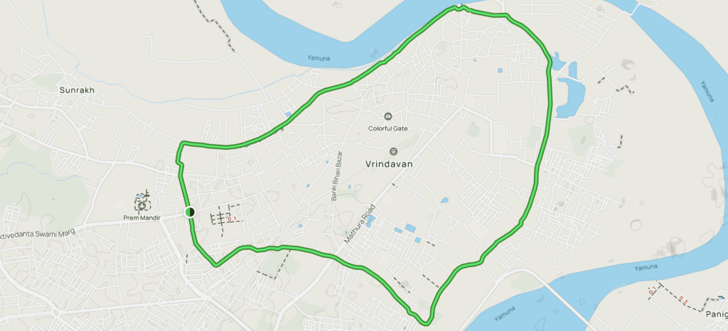 वृंदावन परिक्रमा मार्ग पर भक्त पैदल यात्रा करते हुए, चारों ओर मंदिर और आध्यात्मिक वातावरण